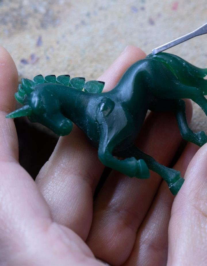 Sculpting the unicorn in green wax